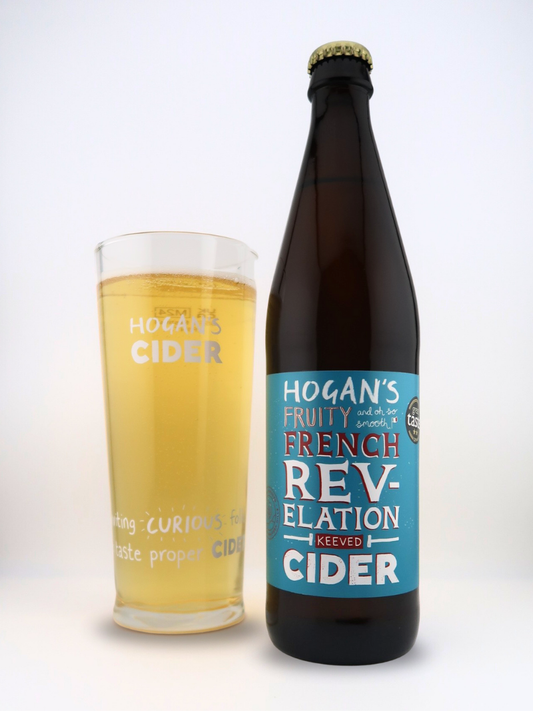 Hogan’s French Revelation – velvety smooth, fruity keeved craft cider bottle beside a branded pint glass filled with golden cider.